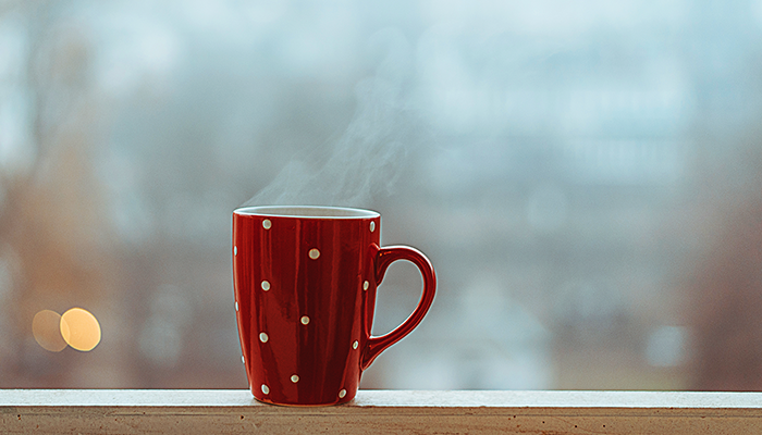 Steaming cup of tea in red spotted mug